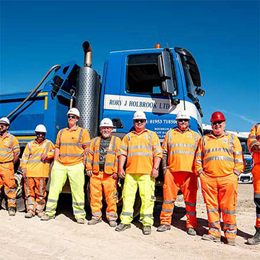 In front of an 8 wheeler, showing Rory's team of drivers